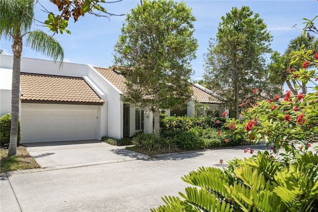 2139 Via Fuentes St Unit 2139, Vero Beach, FL 32963 - view of front facade featuring a tile roof, driveway, an attached garage, and stucco siding