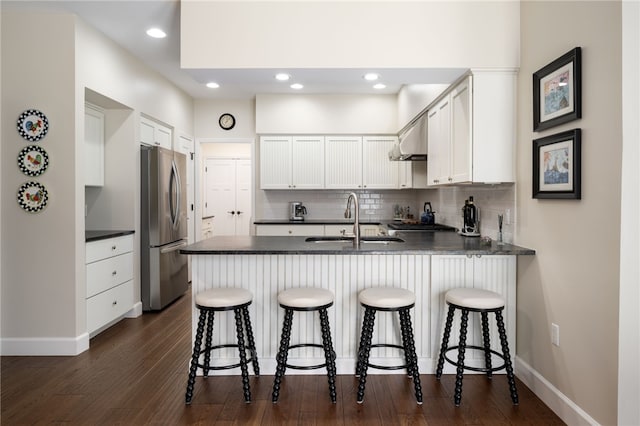 2139 Via Fuentes St Unit 2139, Vero Beach, FL 32963 - kitchen with freestanding refrigerator, a peninsula, dark countertops, decorative backsplash, and recessed lighting