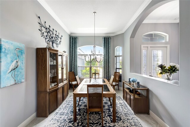 dining space featuring ornamental molding, plenty of natural light, and an inviting chandelier