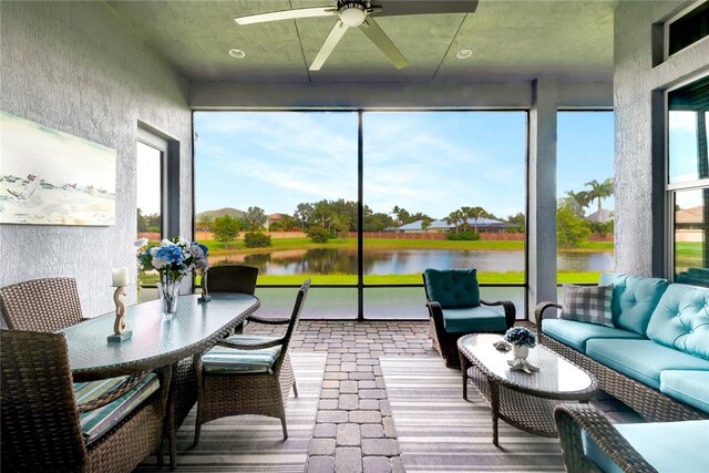 sunroom with a water view and ceiling fan