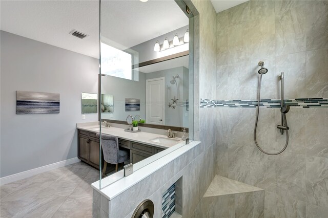 bathroom with vanity, tile patterned floors, and tiled shower