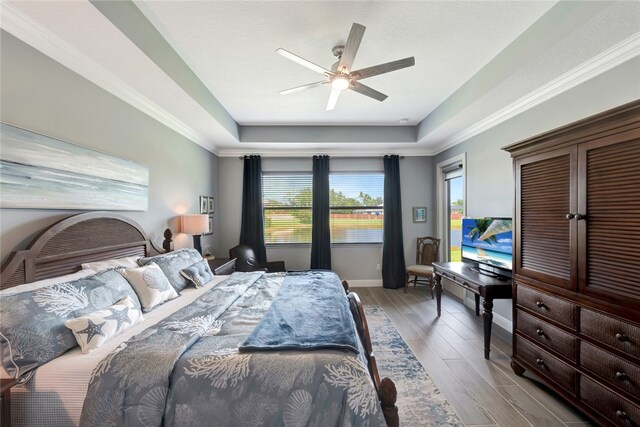 bedroom featuring light hardwood / wood-style floors, ceiling fan, multiple windows, and crown molding