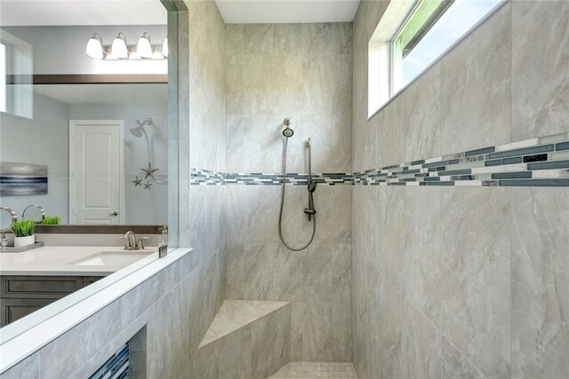 bathroom with vanity and a tile shower