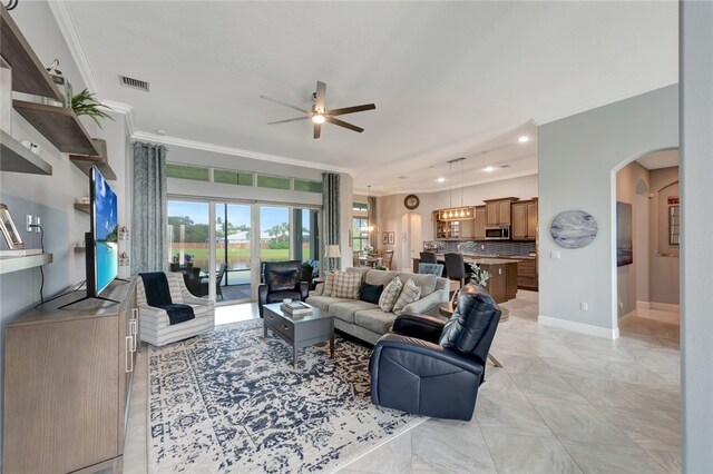 living room featuring ceiling fan with notable chandelier and crown molding