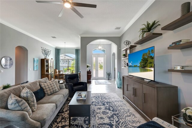 tiled living room featuring ceiling fan, french doors, and ornamental molding