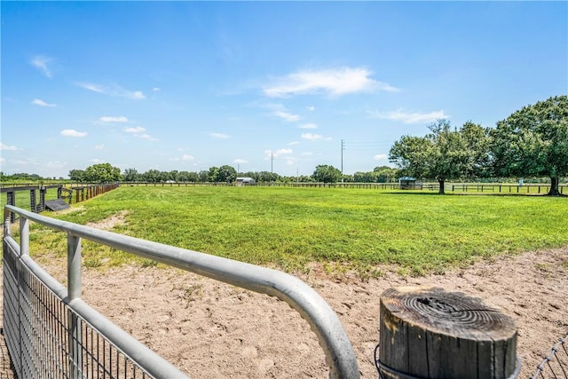 view of yard with fence and a rural view