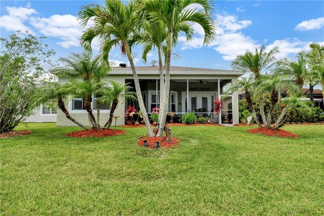 view of front of house featuring a ceiling fan, a sunroom, and a front lawn