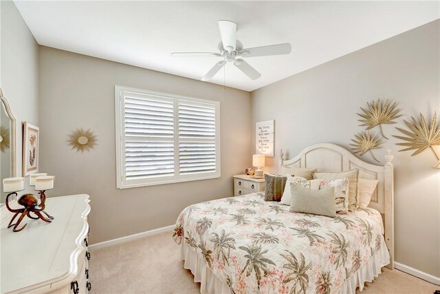 bedroom featuring light colored carpet, baseboards, and ceiling fan