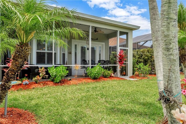 property entrance featuring a yard and ceiling fan