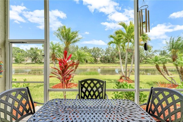 sunroom / solarium featuring a water view