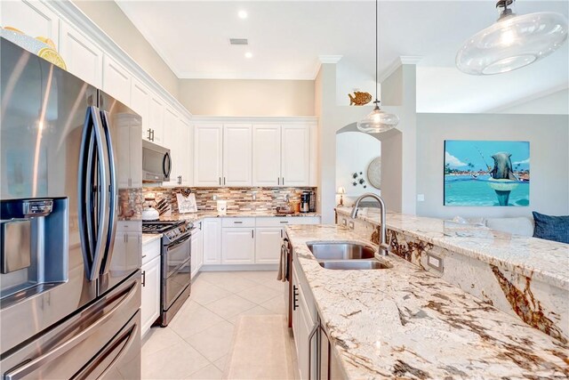 kitchen with light stone counters, a sink, appliances with stainless steel finishes, and tasteful backsplash