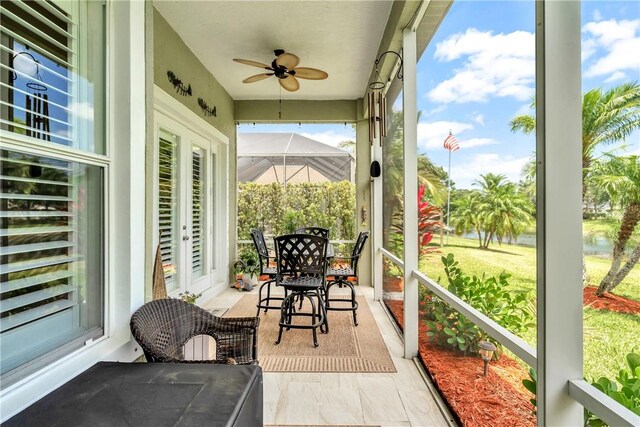 sunroom / solarium with a ceiling fan and french doors