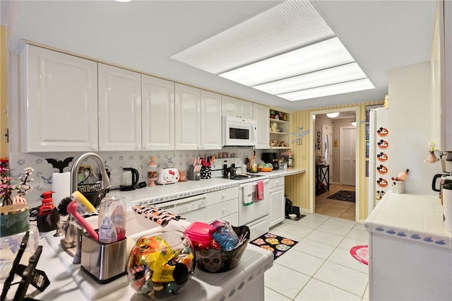 28 Sea Gull Ave, Vero Beach, FL 32960 - kitchen featuring open shelves, light tile patterned floors, white appliances, and white cabinets