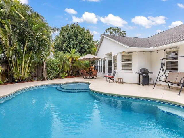 view of swimming pool featuring area for grilling and a patio area