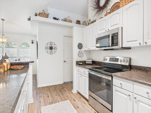 kitchen featuring hanging light fixtures, white cabinets, and appliances with stainless steel finishes