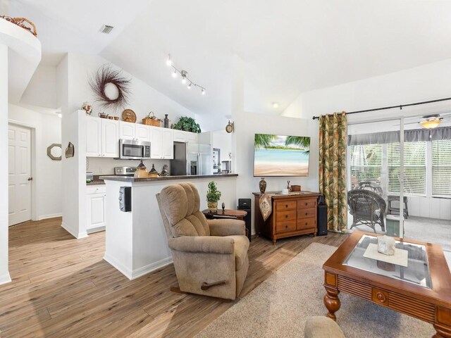 living room featuring light hardwood / wood-style flooring and vaulted ceiling