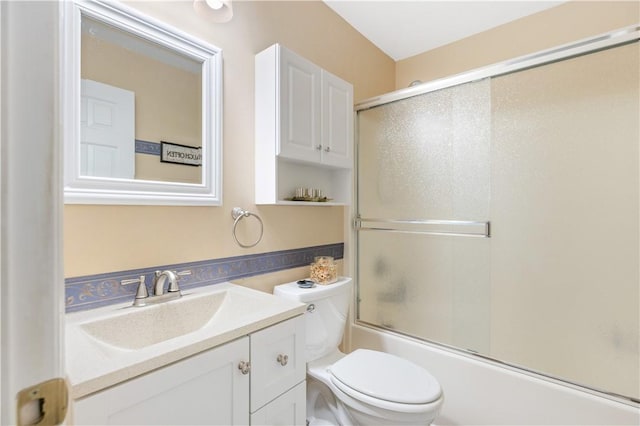 full bathroom featuring enclosed tub / shower combo, vanity, and toilet