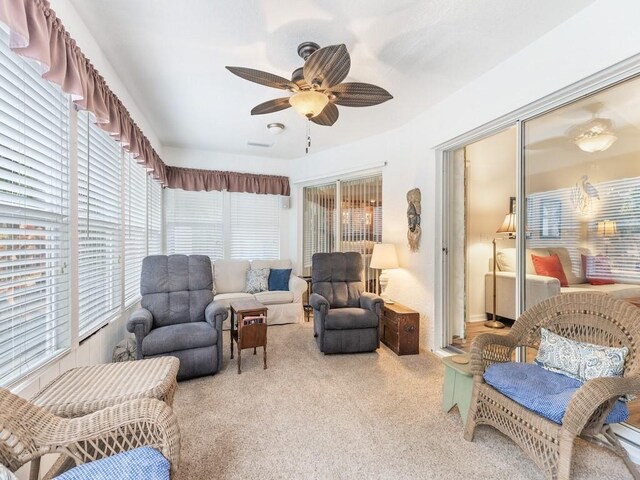 interior space with light carpet, ceiling fan, and a healthy amount of sunlight