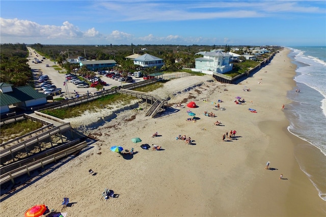 bird's eye view featuring a water view and a beach view