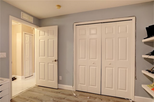 unfurnished bedroom with a closet and light wood-type flooring