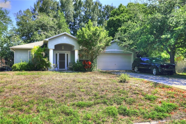 single story home with a garage and a front lawn