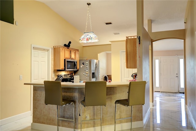 kitchen featuring kitchen peninsula, a breakfast bar, and appliances with stainless steel finishes