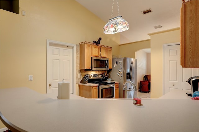 kitchen with pendant lighting, stainless steel appliances, and tasteful backsplash