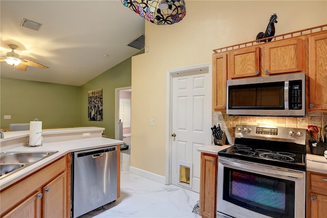 kitchen featuring sink, appliances with stainless steel finishes, tasteful backsplash, ceiling fan, and lofted ceiling