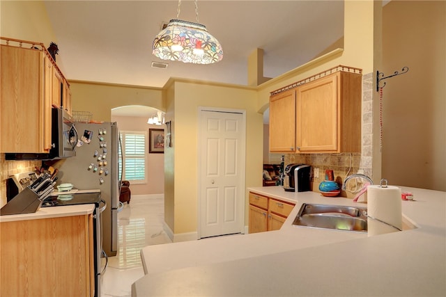 kitchen with tasteful backsplash, stainless steel appliances, decorative light fixtures, light brown cabinetry, and sink