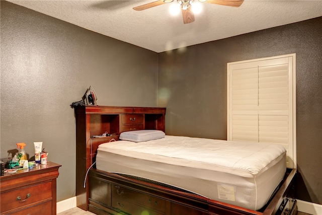 bedroom with a textured ceiling and ceiling fan