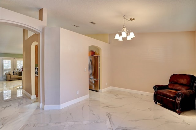 sitting room featuring a notable chandelier and a textured ceiling