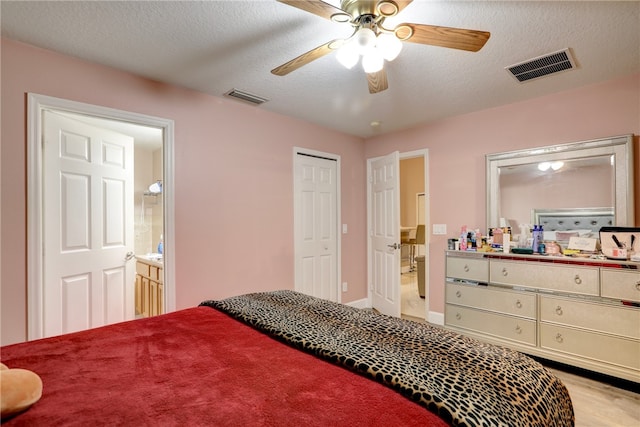 bedroom with a textured ceiling, ensuite bathroom, and ceiling fan