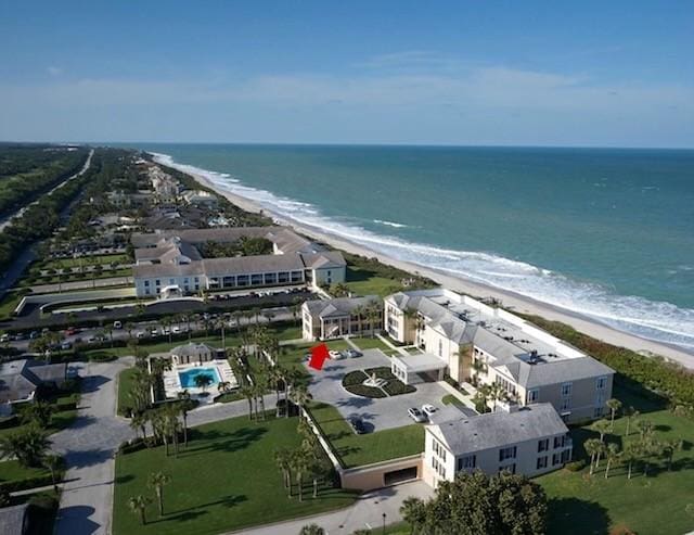 drone / aerial view with a water view and a beach view