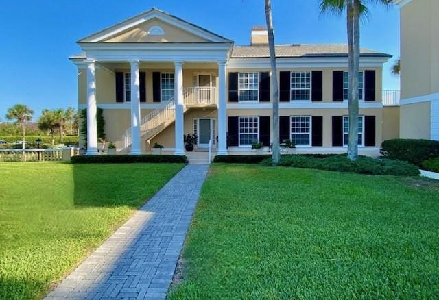 neoclassical home with a front lawn