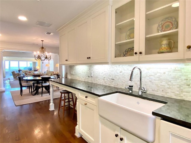 kitchen featuring white cabinetry, sink, dark hardwood / wood-style flooring, decorative backsplash, and hanging light fixtures