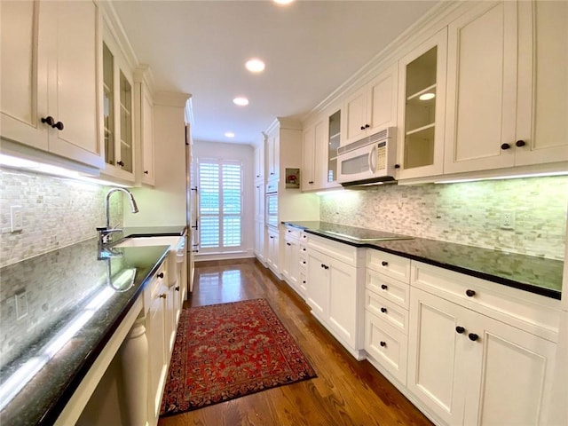 kitchen with white appliances, dark hardwood / wood-style floors, sink, and white cabinets