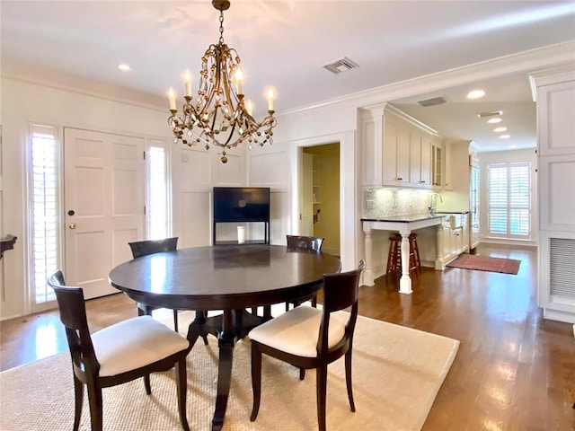 dining space with crown molding and wood-type flooring