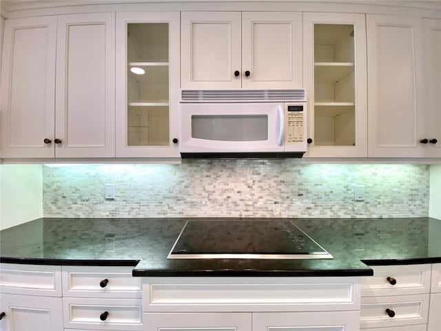 kitchen featuring white cabinetry, black electric cooktop, and decorative backsplash