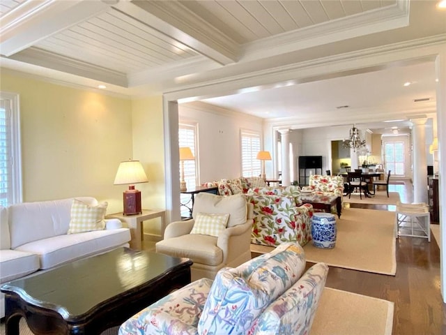 living room featuring decorative columns, beamed ceiling, dark hardwood / wood-style flooring, a notable chandelier, and crown molding