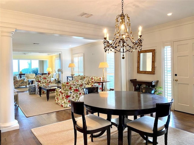 dining space with dark hardwood / wood-style flooring, ornamental molding, and decorative columns