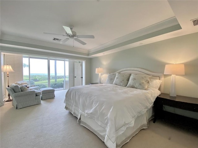 carpeted bedroom with a tray ceiling, access to outside, ornamental molding, and ceiling fan