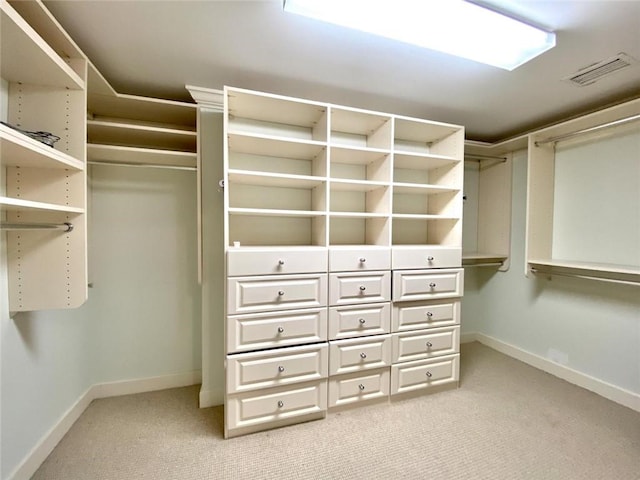 walk in closet featuring light colored carpet