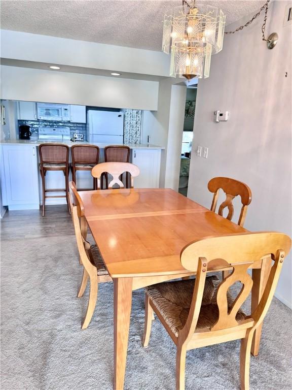 dining space with a chandelier and a textured ceiling