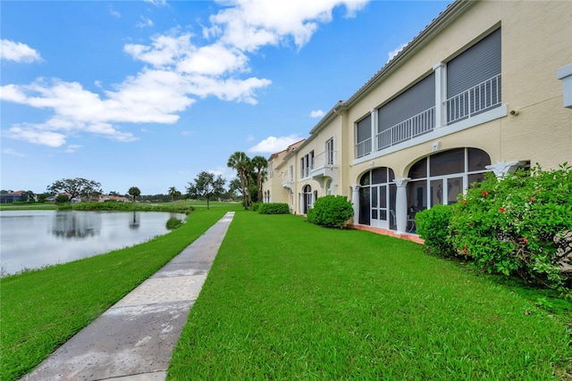 view of community with a water view and a yard