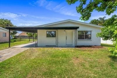 view of front of home with a front yard and a carport