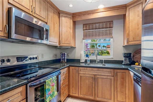 kitchen featuring appliances with stainless steel finishes, brown cabinets, and a sink