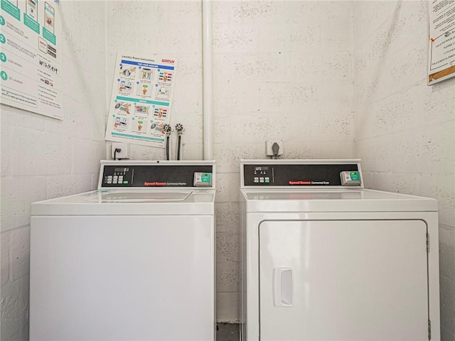 62 Woodland Dr Unit 201, Vero Beach, FL 32962 - shared laundry room featuring washer and clothes dryer and concrete block wall