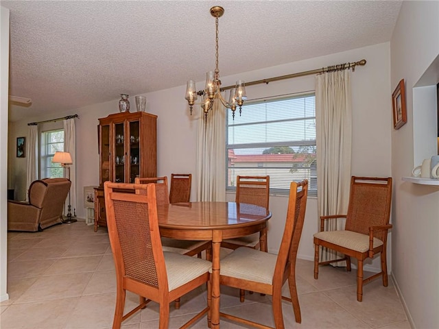 62 Woodland Dr Unit 201, Vero Beach, FL 32962 - dining room with a chandelier, a textured ceiling, light tile patterned floors, and baseboards