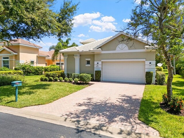 view of front of home with a front yard and a garage