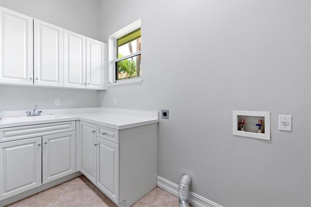 clothes washing area featuring cabinets, washer hookup, electric dryer hookup, sink, and light tile patterned floors